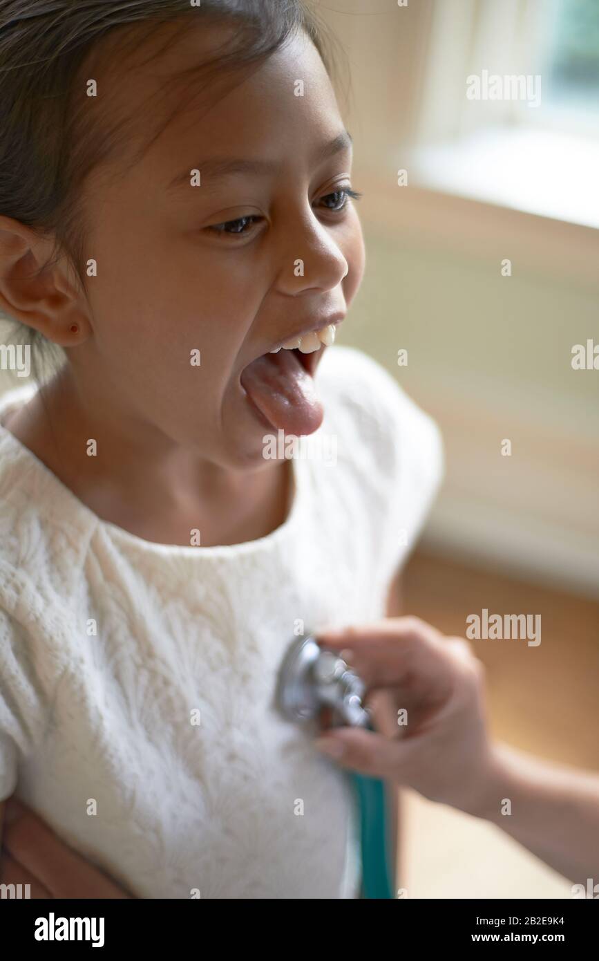 Allgemeinmediziner mit einem Stethoskop während der Überprüfung ein junges Mädchen Stockfoto
