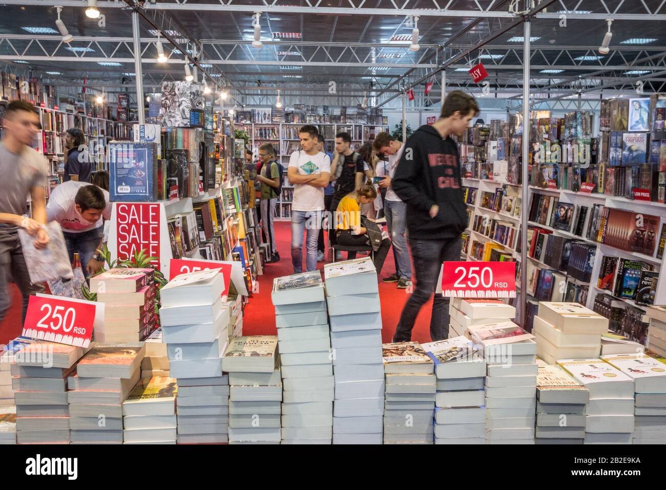 Belgrad, SERBIEN - 25. OKTOBER 2019: Inneneinrichtung eines serbischen Buchladens zur Hauptverkehrszeit voller Menschen, Leser, die mit einer Geschwindigkeitsunschärfe vorbeikommen, und Haufen o Stockfoto