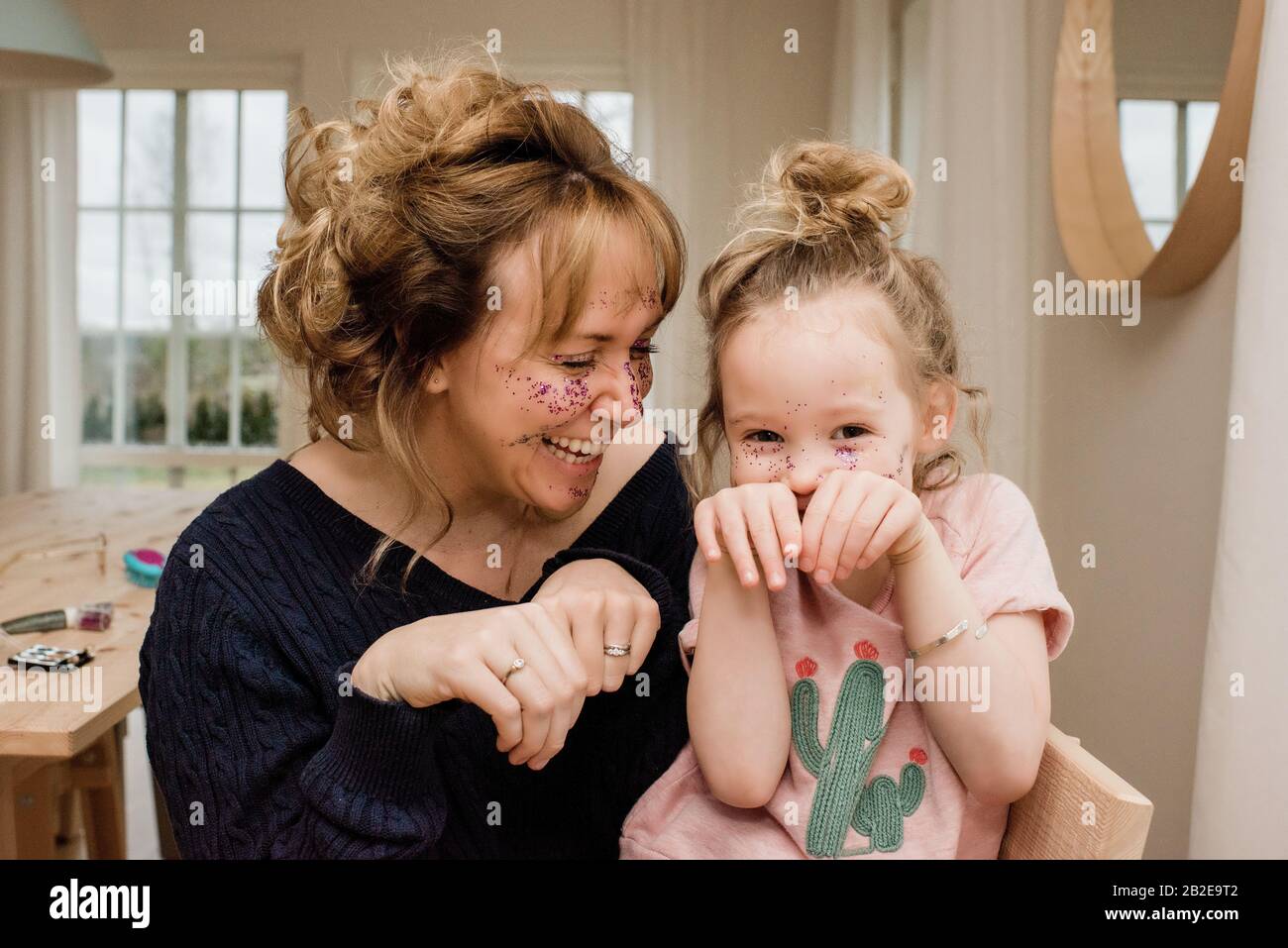 Mutter und Tochter ziehen dumme Gesichter beim Spielen zu Hause Stockfoto