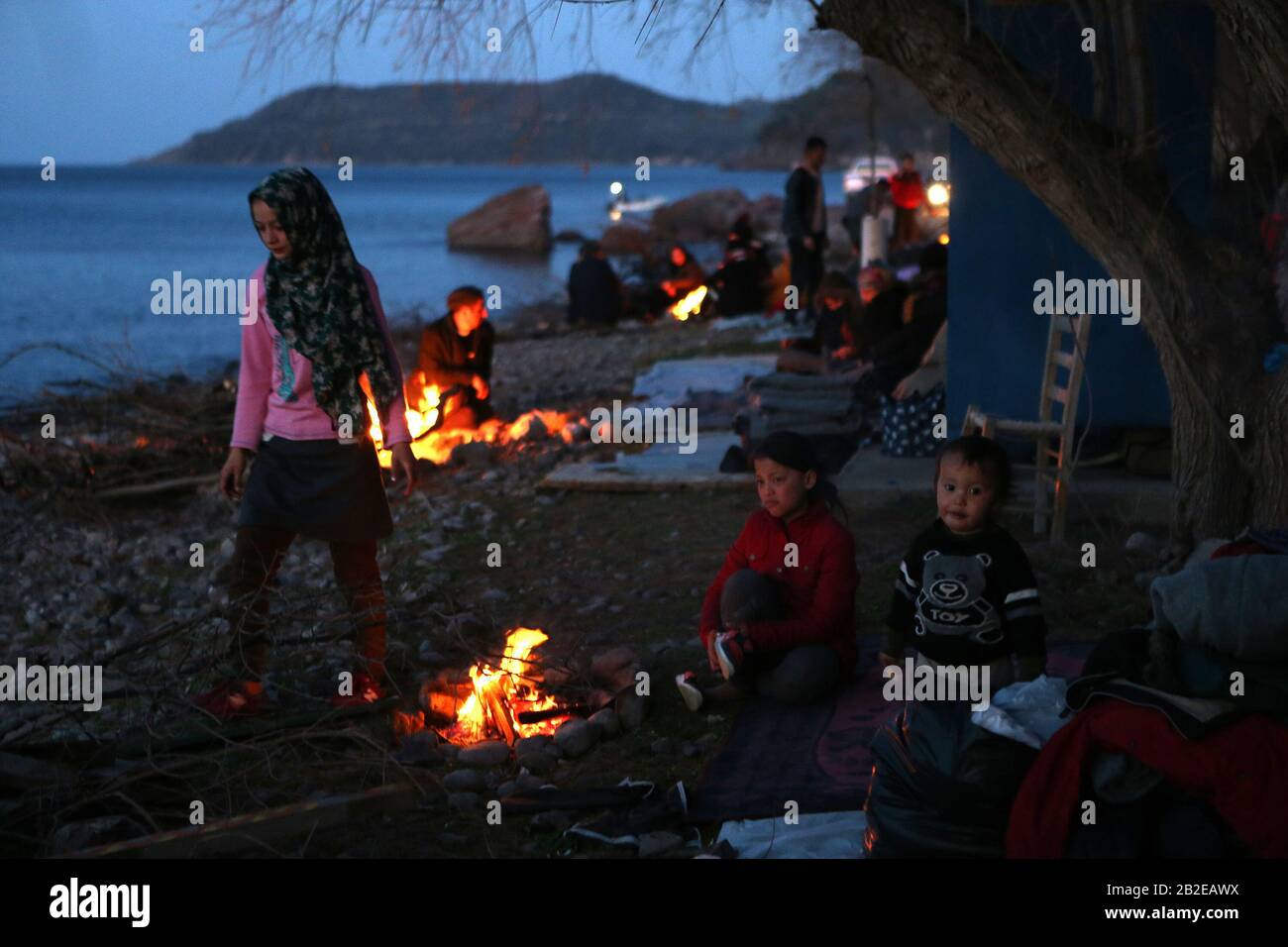 Lesvos, Griechenland. März 2020. Kinder, die aus der Türkei gekommen sind, versuchen sich durch das Feuer in Skala Sikaminias auf der Insel Lesvos, Griechenland, am 2. März 2020 zu wärmen. Griechenland habe eine härtere Haltung eingenommen und die Migrationsherausforderung als nationale Sicherheitsfrage betrachtet, sagte Innenminister Takis Theodorikakos am Montag. Kredit: Marios Lolos/Xinhua/Alamy Live News Stockfoto