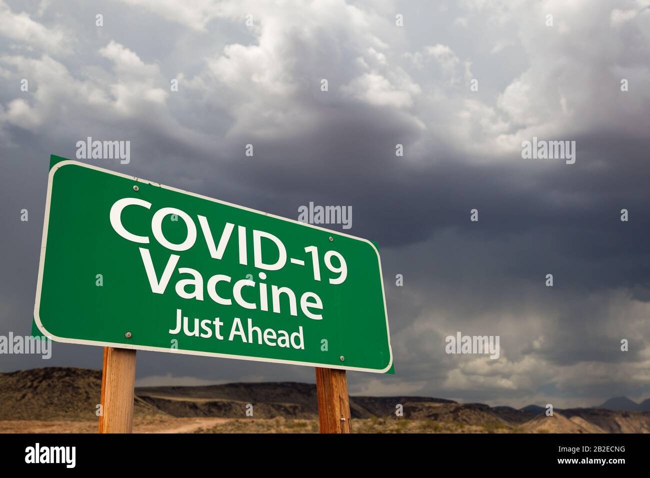 COVID-19 Coronavirus Impfstoff Green Road Sign Gegen Unheilvollen Stürmischen Bewölkten Himmel. Stockfoto