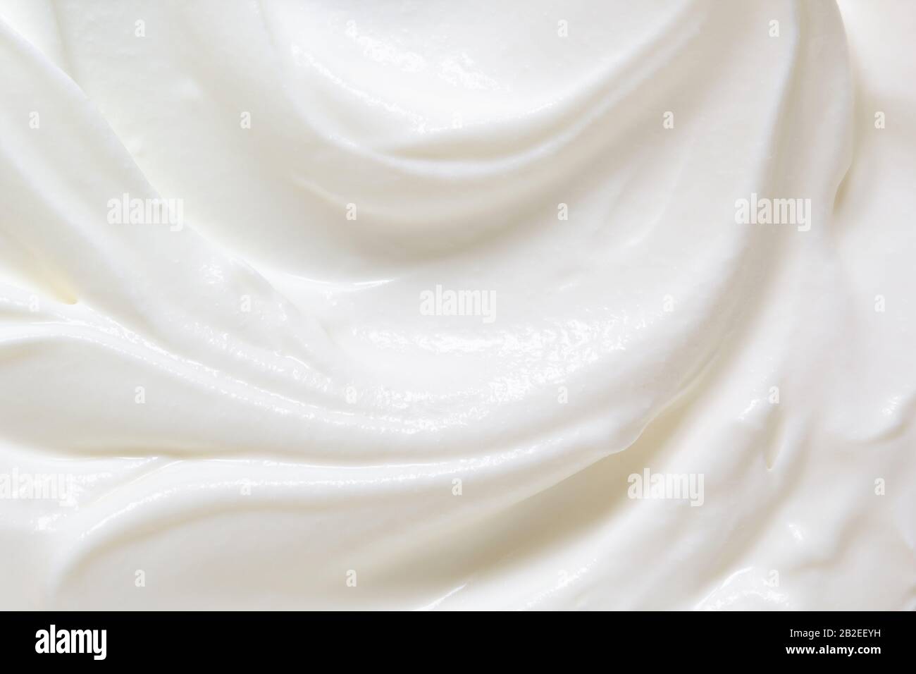 Saure Sahne, griechische Joghurt Textur. Weiße Molkereiprodukte, Verwirbelung im Nahaufnahme. Cremig gesunde Naturkost-Makrofotografie. Draufsicht Stockfoto