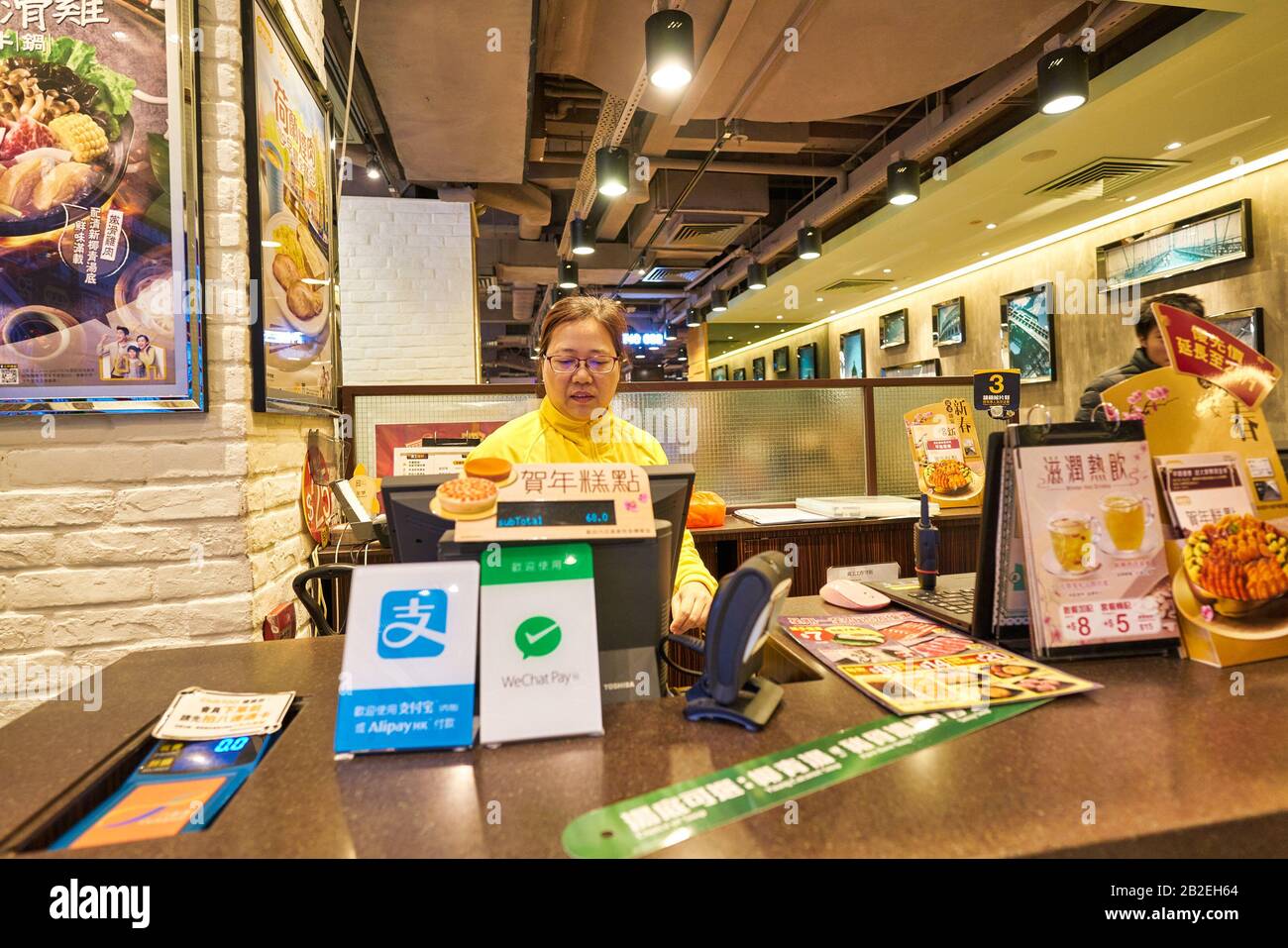 Hongkong, CHINA - CIRCA JANUAR 2019: Innenporträt der Kassiererin im Café de Coral Restaurant in Hongkong. Stockfoto