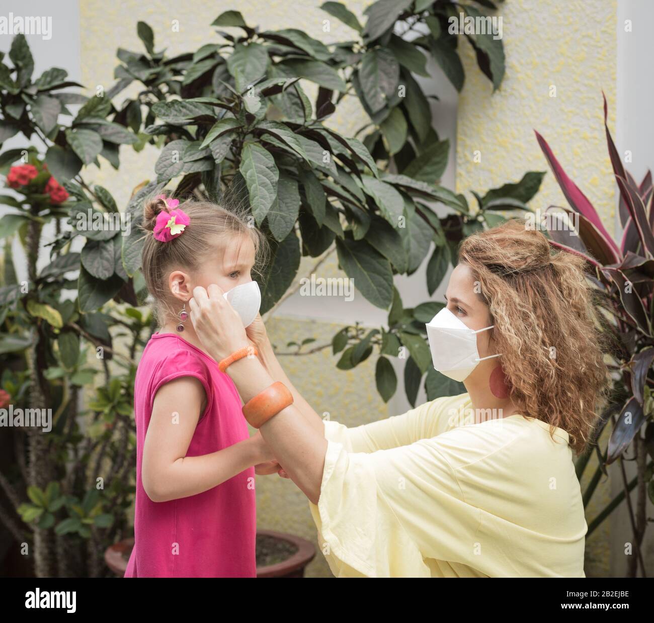 Frau und Tochter tragen eine Einwegmaske, um Virusinfektionen zu vermeiden. Schutz vor Coronavirus Stockfoto