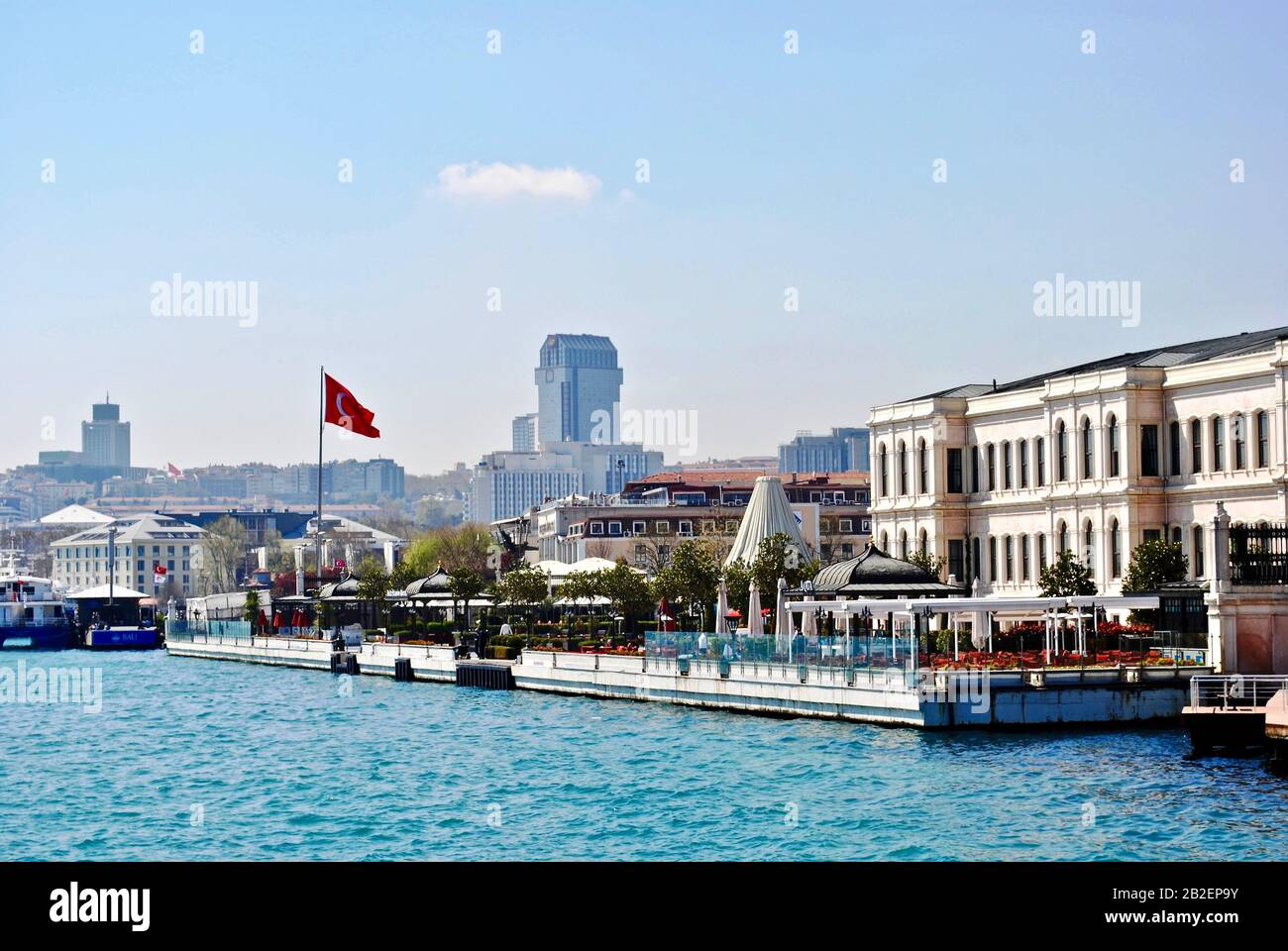 Istanbul, TÜRKEI: Der Ciragan-Palast war einst der Palast osmanischer Sultane und ist heute ein Luxushotel. Hotel von der Bosporus Straße mit türkischer Flagge gesehen Stockfoto