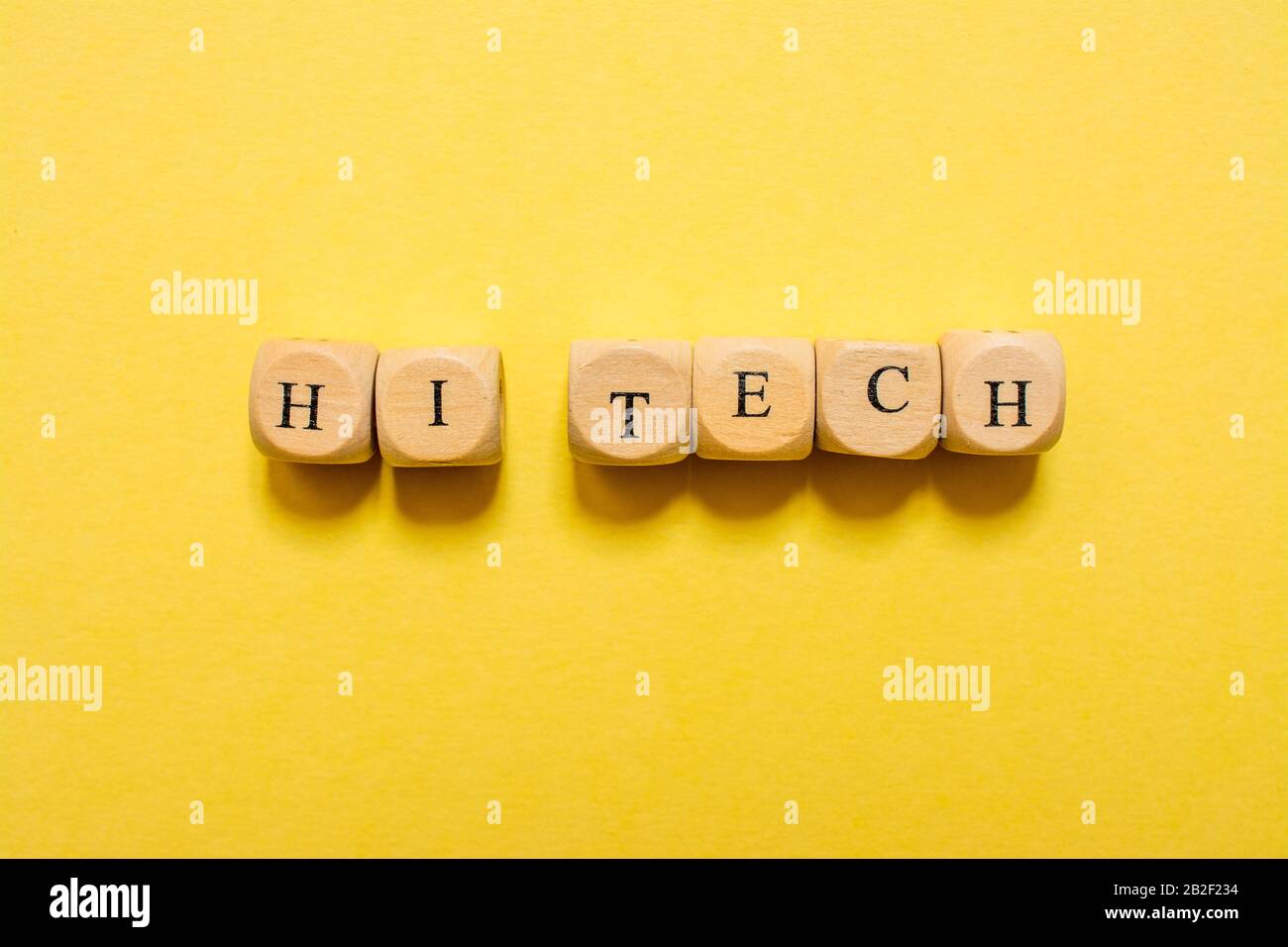 Das Wort Hi Tech, Text mit Würfeln auf gelbem Hintergrund Stockfoto