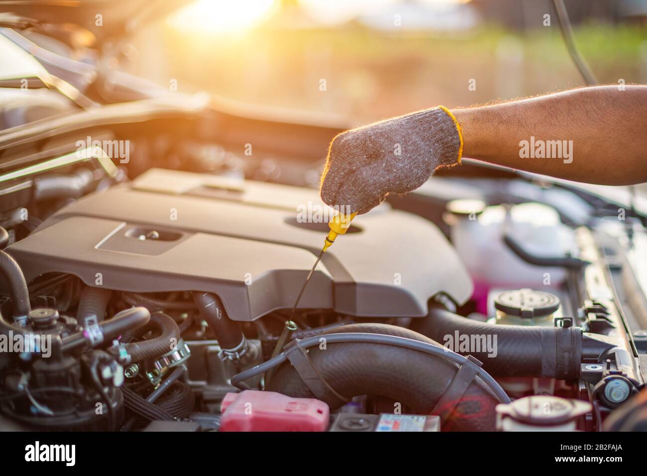 Service- und Wartungskonzept für das Auto: Die Hand des Technikers, der den Motor eines modernen Autos überprüft oder befestigt Stockfoto