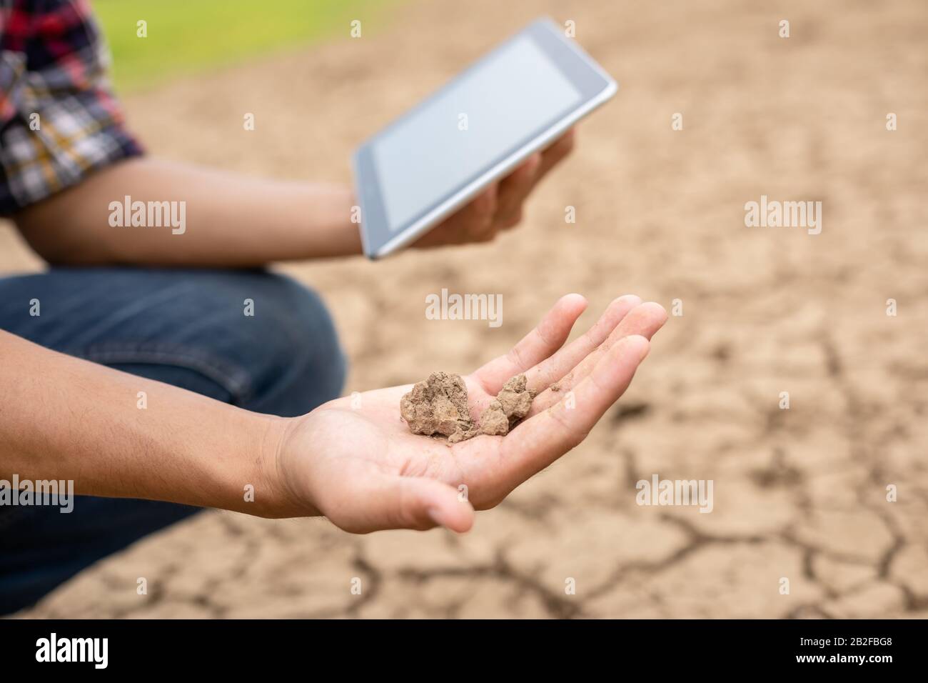 Junger asiatischer Ingenieur, der vor Ort am Staudamm arbeitet und den Boden auf Dürreprobleme überprüft Stockfoto