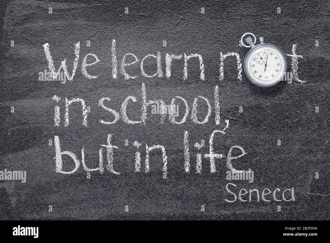 Wir lernen nicht in der Schule, sondern im Leben - ein Zitat des alten römischen Philosophen Seneca, das auf dem Schwarzen Brett geschrieben wurde Stockfoto