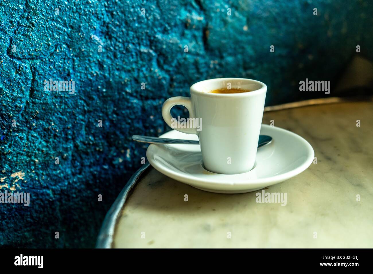 Tasse Kaffee in einem schönen Hipster-Café. Weich fokussiertes Bild. Tasse Espresso auf dem alten Tisch der Cafeteria. Stockfoto