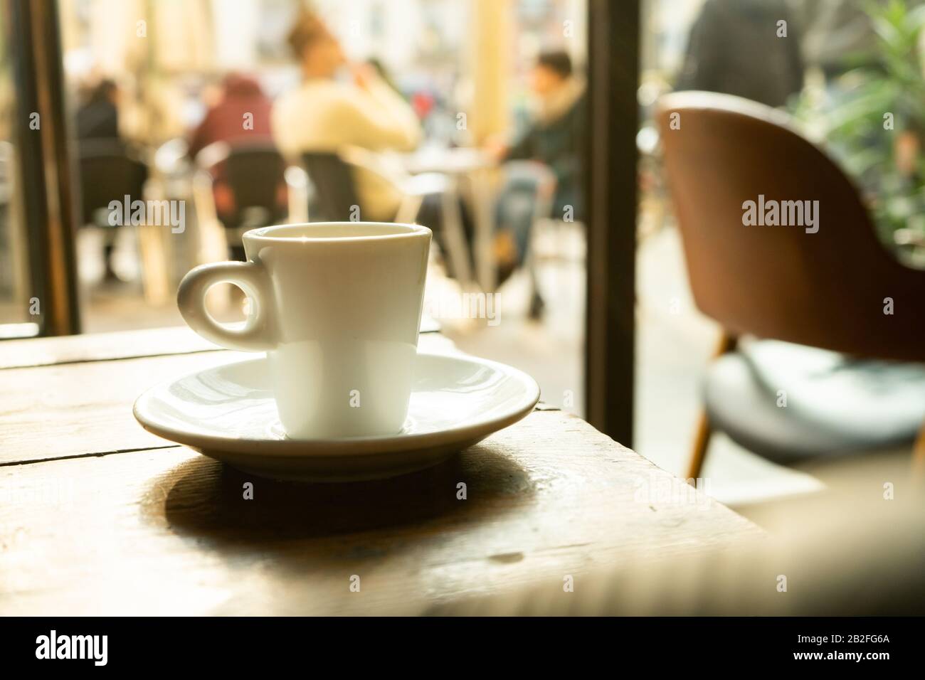 Tasse Kaffee in einem schönen Hipster-Café. Weich fokussiertes Bild. Tasse Espresso auf dem alten Tisch der Cafeteria. Stockfoto