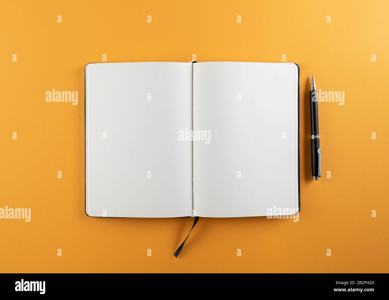 Öffnen Sie das Tagebuch oder Notizbuch mit leeren weißen Seiten auf der orangefarbenen Hintergrundvorlage Stockfoto
