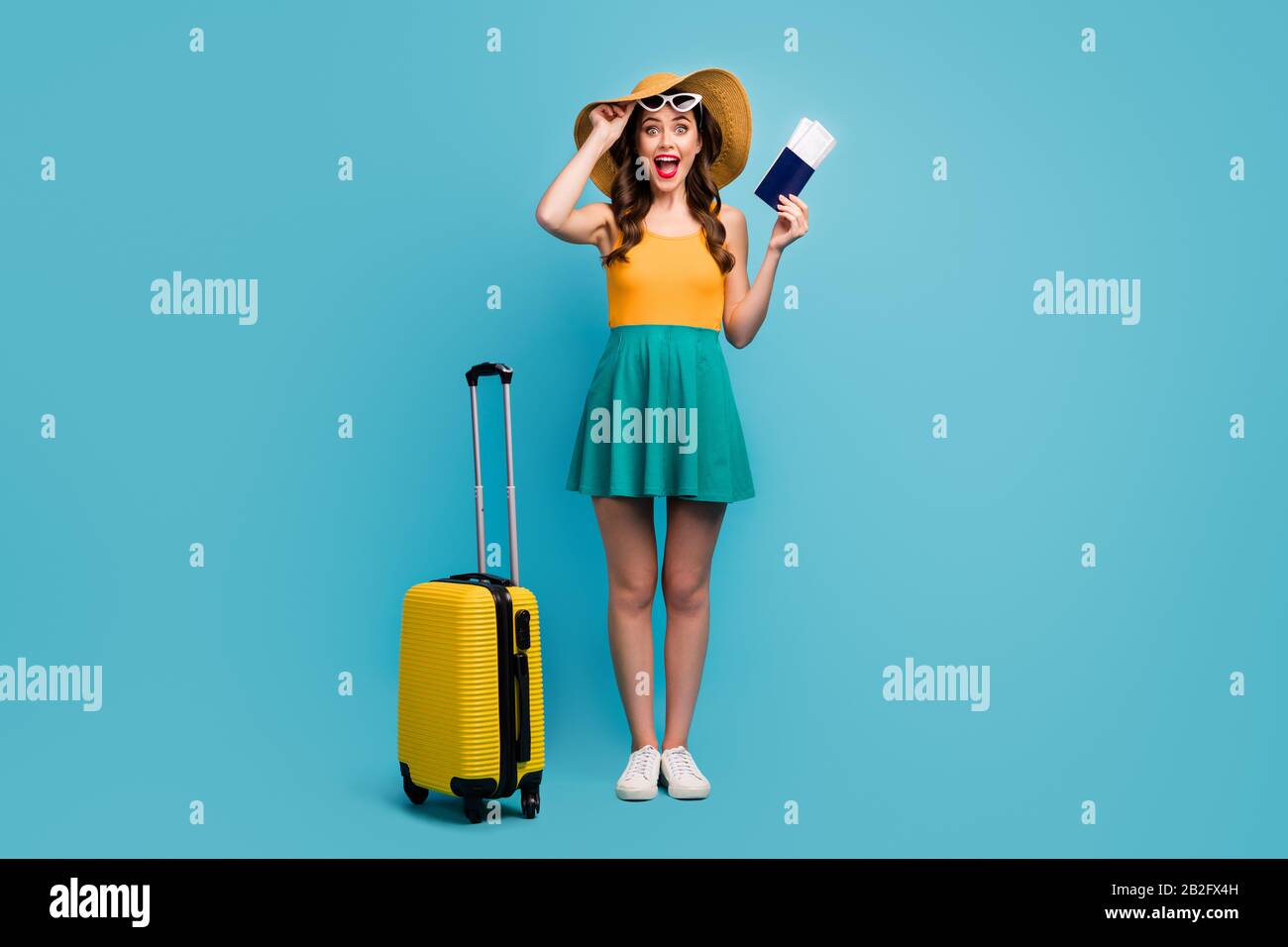 Ganzkörperfoto der hübschen Dame Reisende halten Passkarten Rollkoffer Gepäck Flughafen Billigflüge tragen Sonnenschein kurzes Sommerkleid Stockfoto