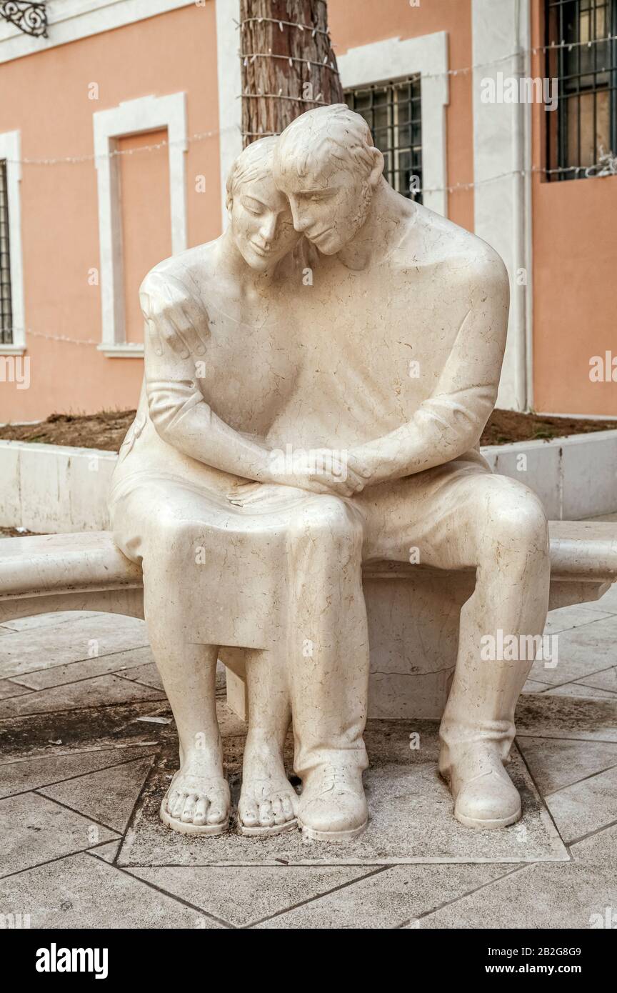 Italien Marken Pesaro Piazza Mosca - Außenansicht des Palazzo Mosca - "Scultura della Memoria" ( SClpture of Memory ) von Giuliano Vangi - Junges Paar, das auf einer Bank sitzt Stockfoto