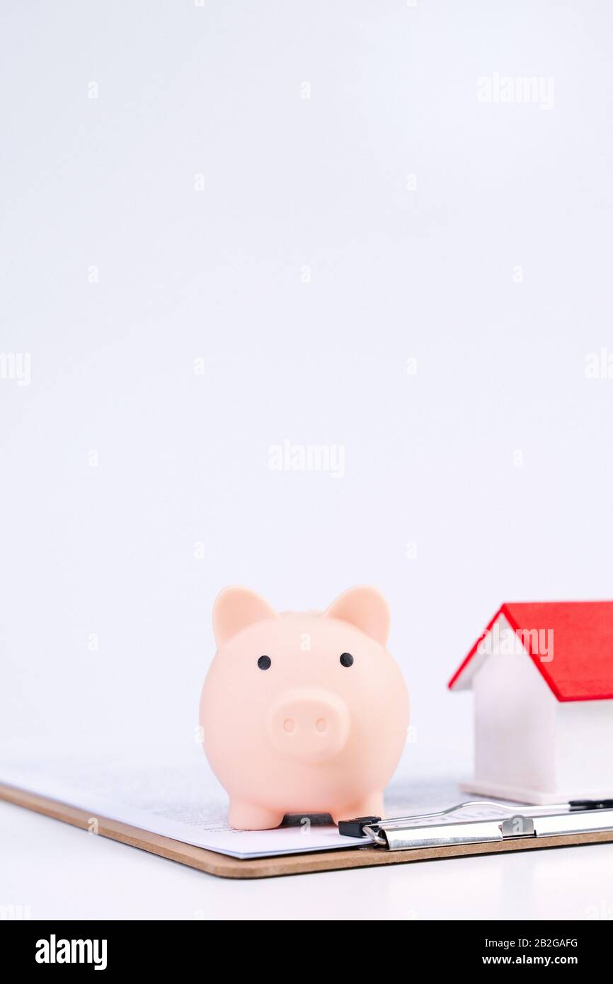 Finanzklage - Piggy Bank, wunderschönes rot-weißes Holzhausmodell auf weißem Hintergrund, spart Geld beim Kauf von Versicherungen, Nahaufnahme, Kopierplatz. Stockfoto