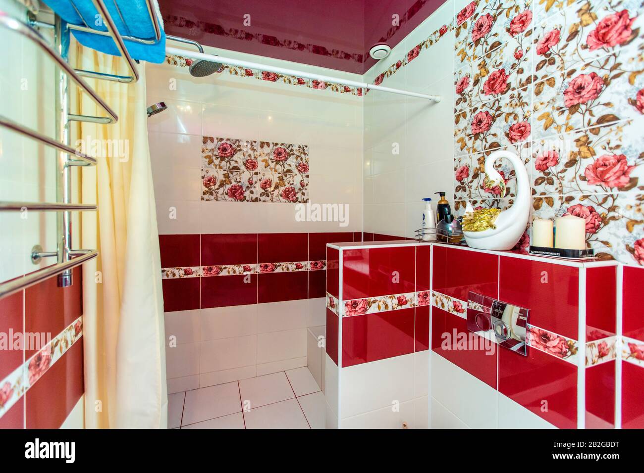 Großes Badezimmer im Cottage in rot-weißen Farben. Kastanienbraune und weiße Fliesen, Fliesen mit roten Farben. Toilette, Dusche. Weiße und kastanienbraune Fliesen auf dem fl Stockfoto