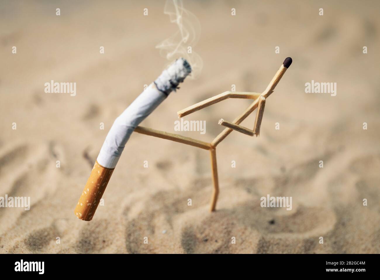 Raucherkonzept stoppen - Spielmann tritt eine brennende Zigarette ab Stockfoto