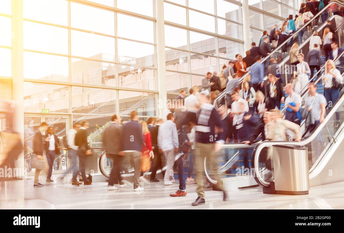 Anonyme Menschenmenge bei Messe oder Kongress auf einer Rolltreppe Stockfoto