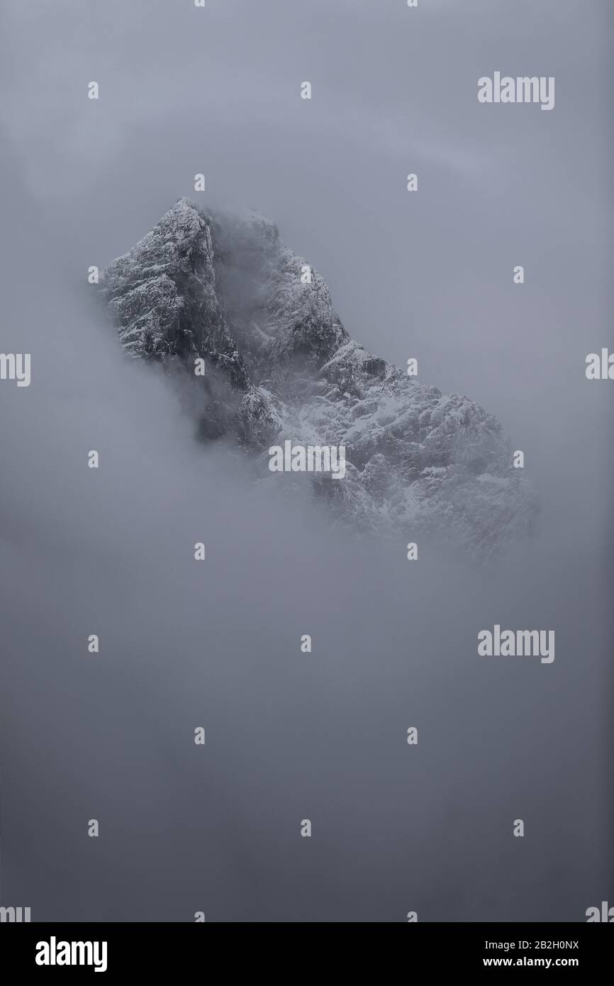 Mystischer Berg mit Neuschnee durch den Nebel in Jotunheimen, Norwegen Stockfoto