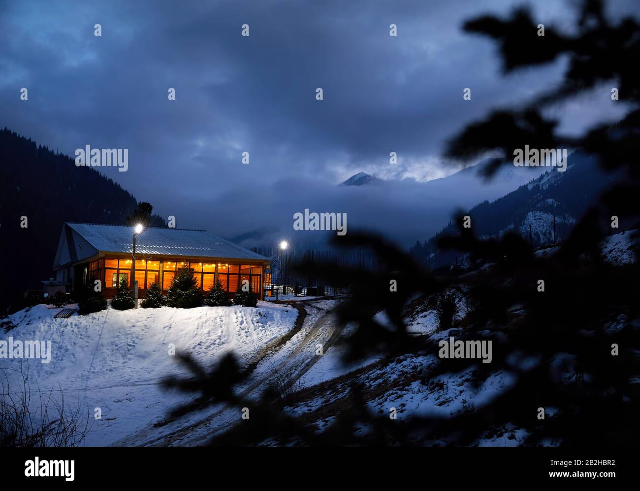 Modernes Holzhaus mit gelben Glühbirnen im Bergresort Stockfoto