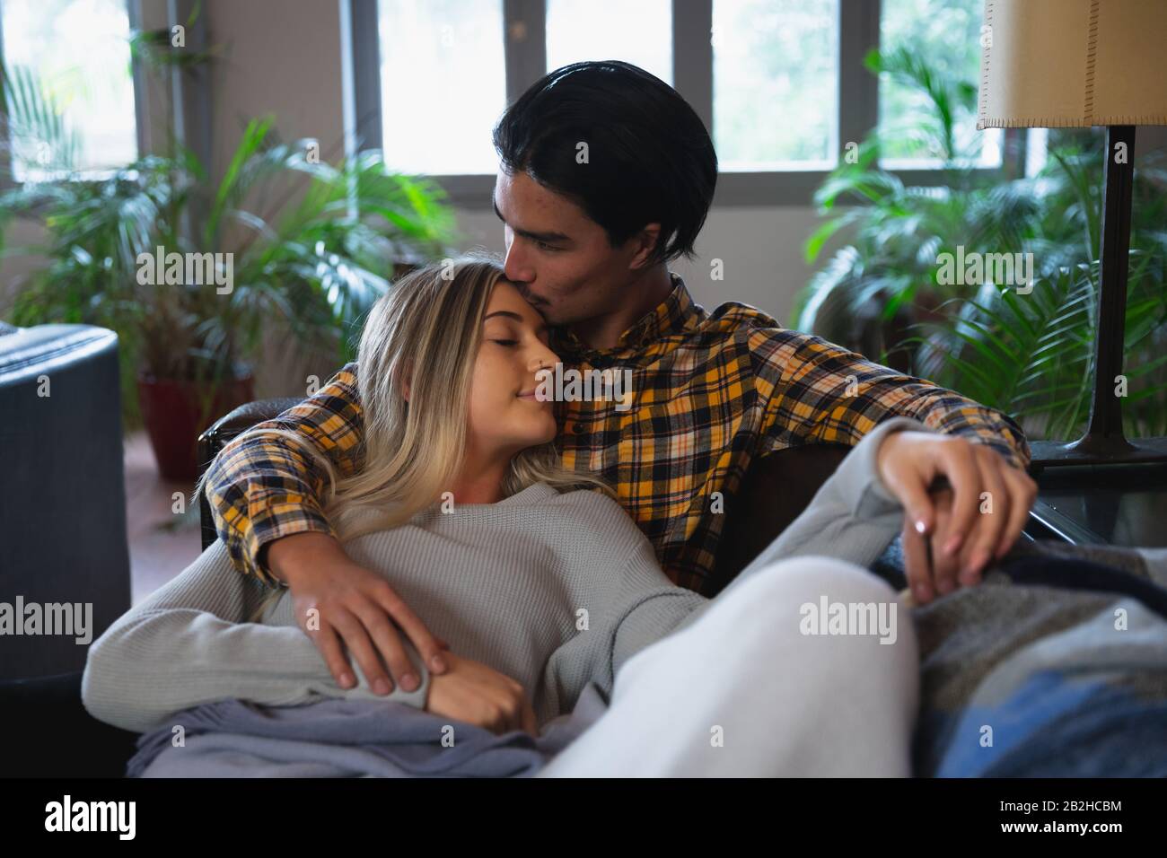 Junges Paar küsst auf dem Sofa Stockfoto