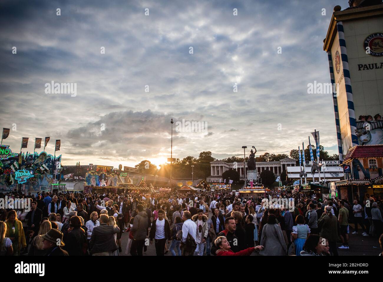 Die Sonne geht über das Oktoberfestgelände, Hunderte feiern das Bayerische Bierfest in München mit viel Essen, Bier und Spaß. Stockfoto