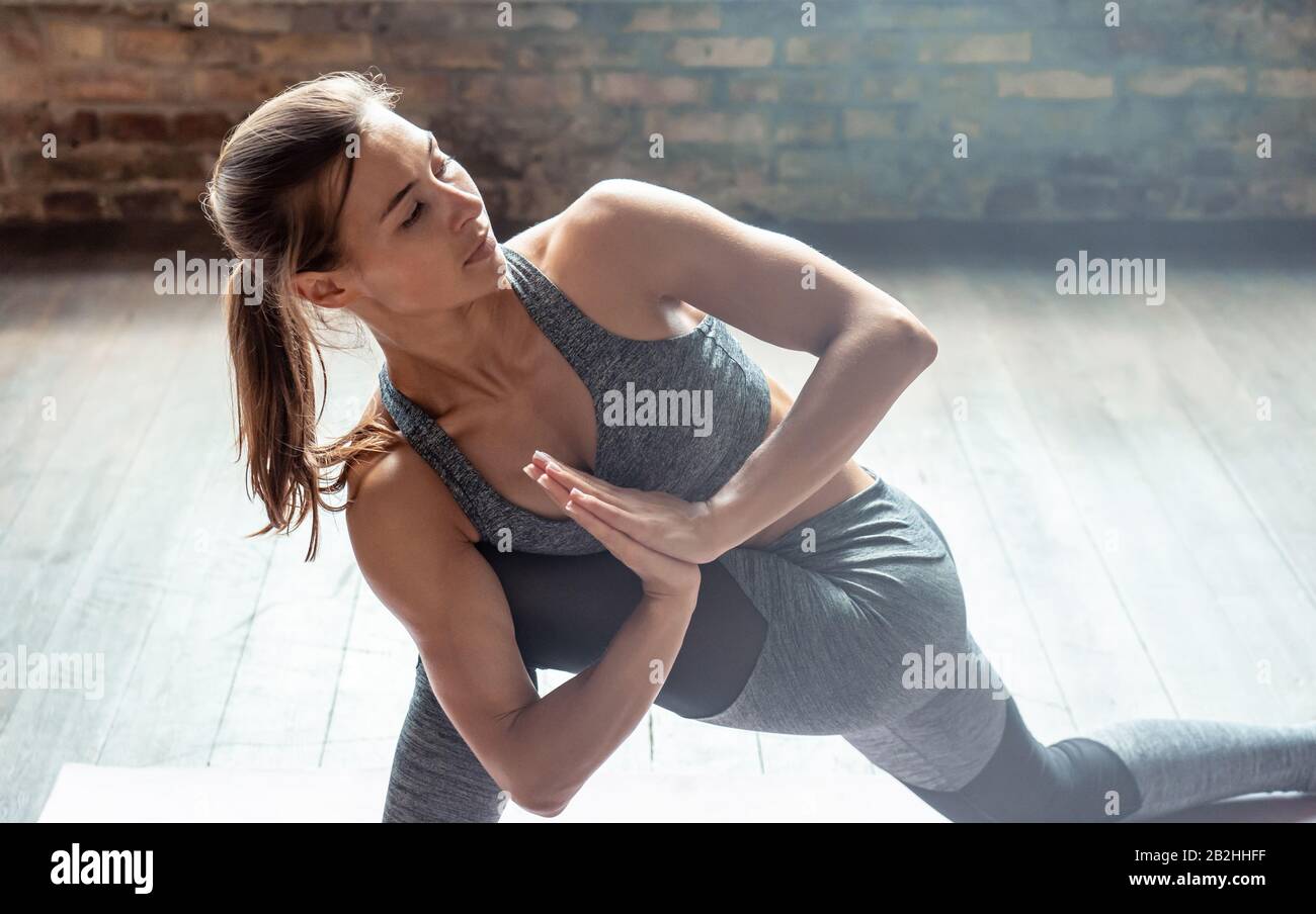 Junge sportliche Mädchen üben Yoga-Halbmond Ausfallknie stellen einen gesunden Lebensstil dar. Stockfoto