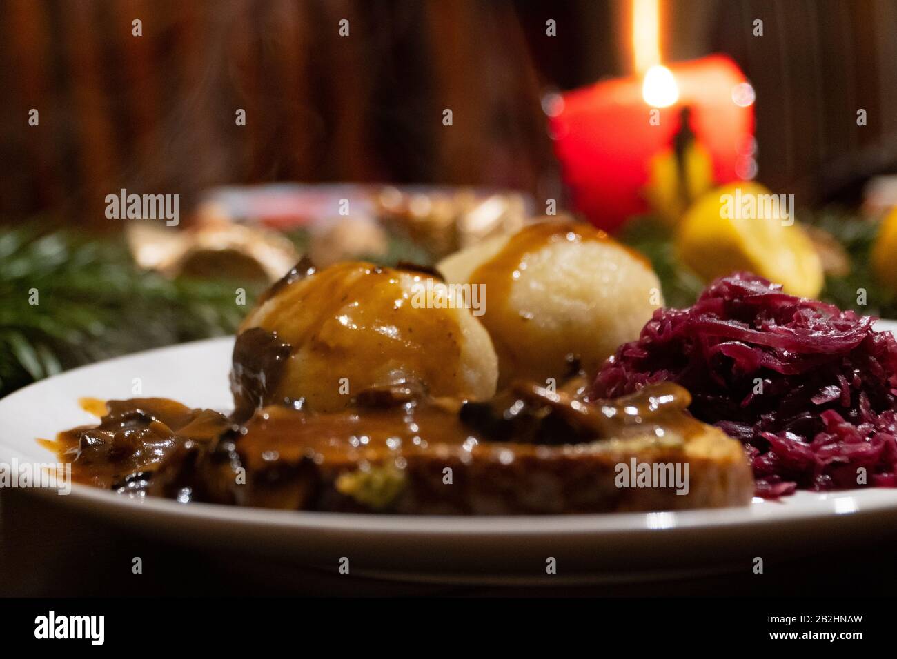 Nahaufnahme eines Tellers mit zwei Knödel, Rotkohl, Braten und brauner Soße - Vegan-Weihnachtsessen Stockfoto