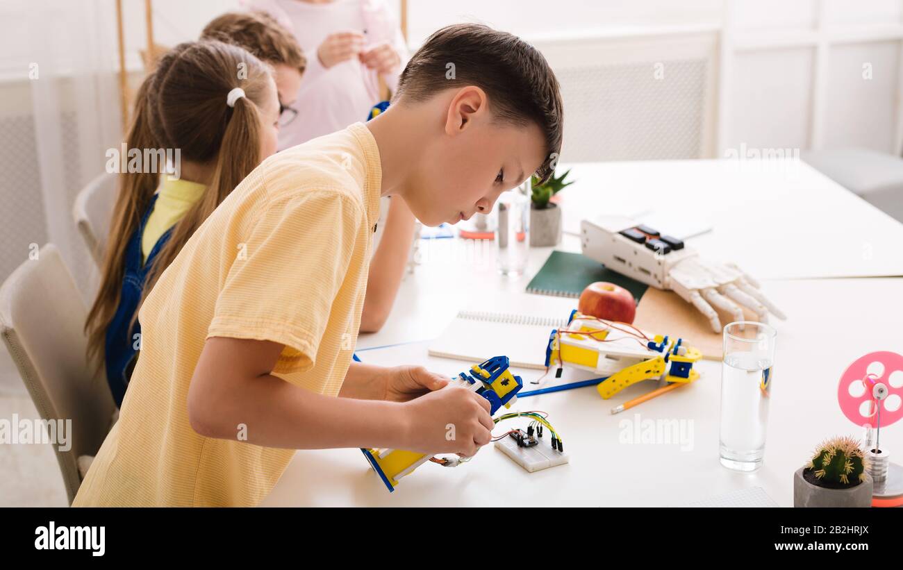 Roboterausbildung. Intelligenter Teenager, der einen heimwerkerroboter konstruiert Stockfoto