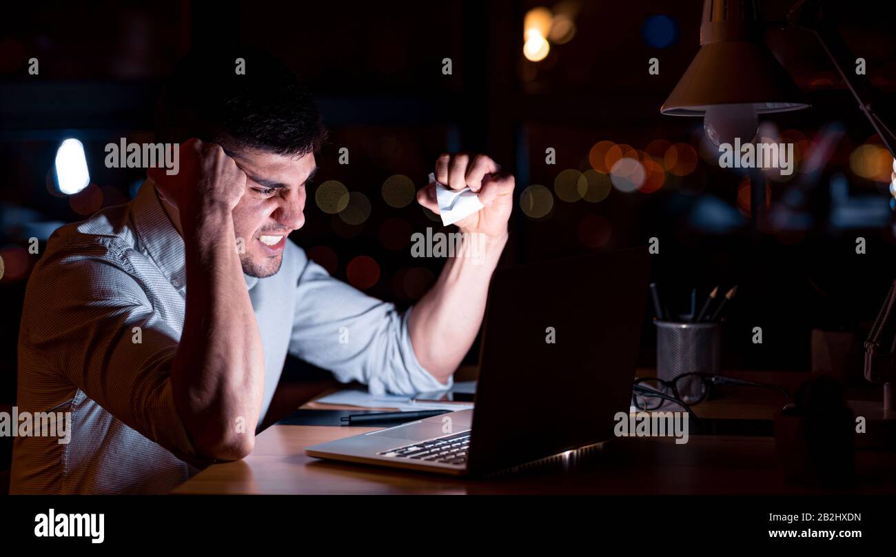 Verärgerter Geschäftsmann Im Büro Von Panorama, Das Papier Mit Einem Zerbröckelnden Laptop Stockfoto