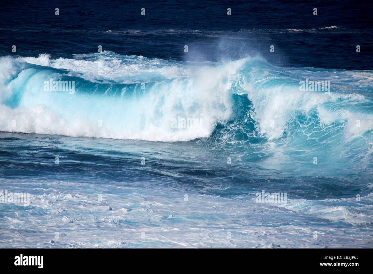 Das Walzen der blauen Wellen, die im Meer vor der Küste der kanarischen Inseln auf Lanzarote zusammenstoßen, spanien Stockfoto
