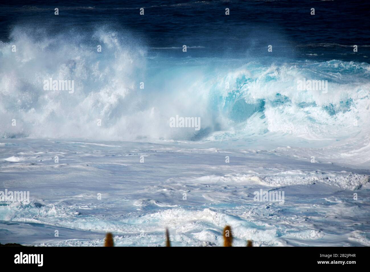 Das Walzen der blauen Wellen, die im Meer vor der Küste der kanarischen Inseln auf Lanzarote zusammenstoßen, spanien Stockfoto