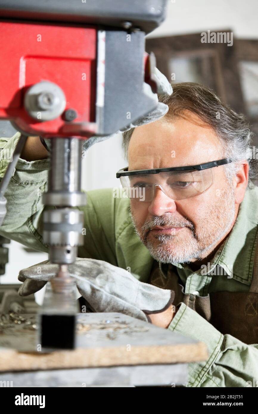 Nahaufnahme eines reifen Mannes, der eine Schutzbrille trägt, die sich auf die Arbeit konzentriert Stockfoto