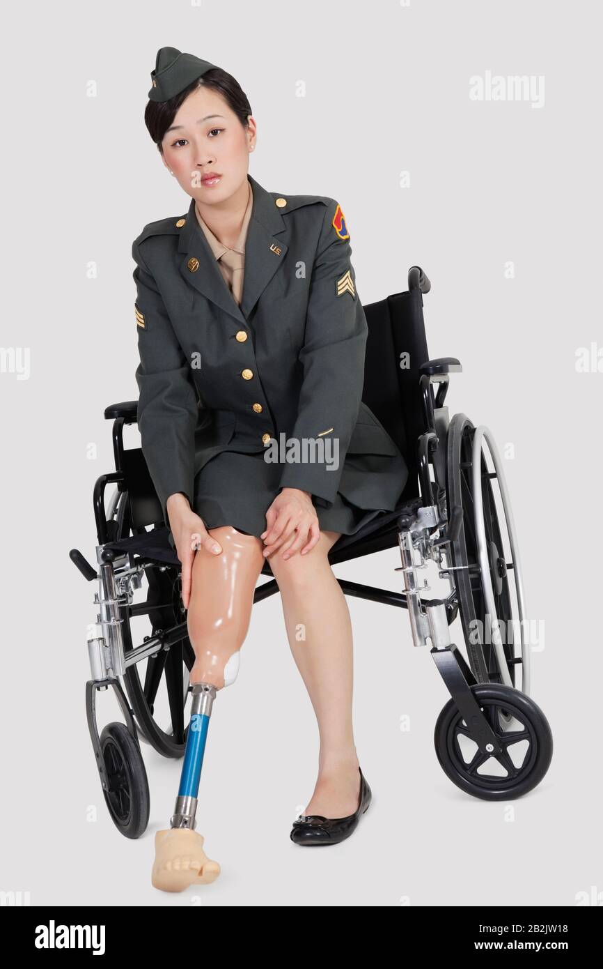 Porträt eines weiblichen US-Militäroffiziers im Rollstuhl sitzenden Prothesenfuß über grauen Hintergründen Stockfoto