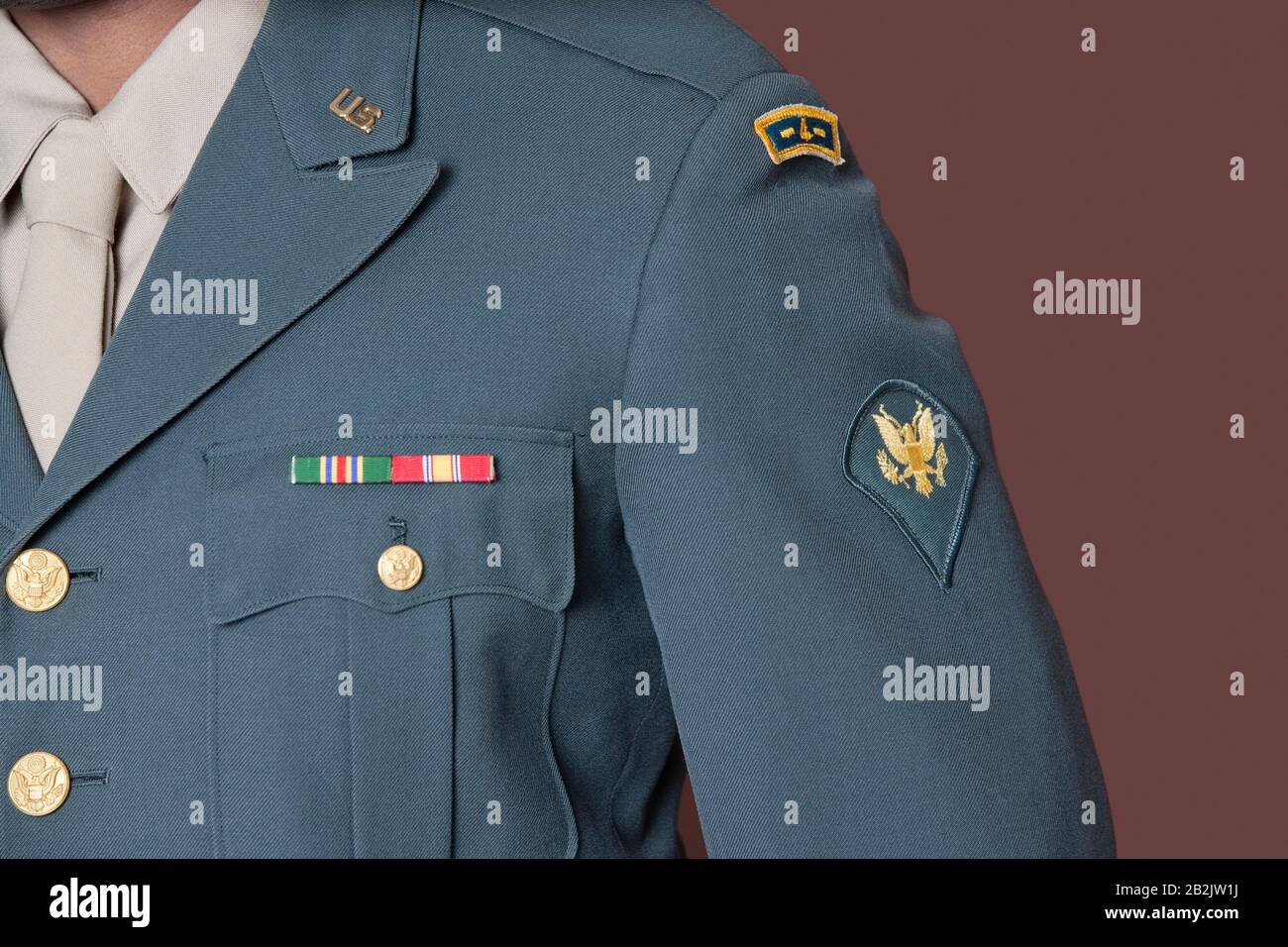 Nahaufnahme der Uniform des US-Militärbeamten mit Abzeichen über braunem Hintergrund Stockfoto