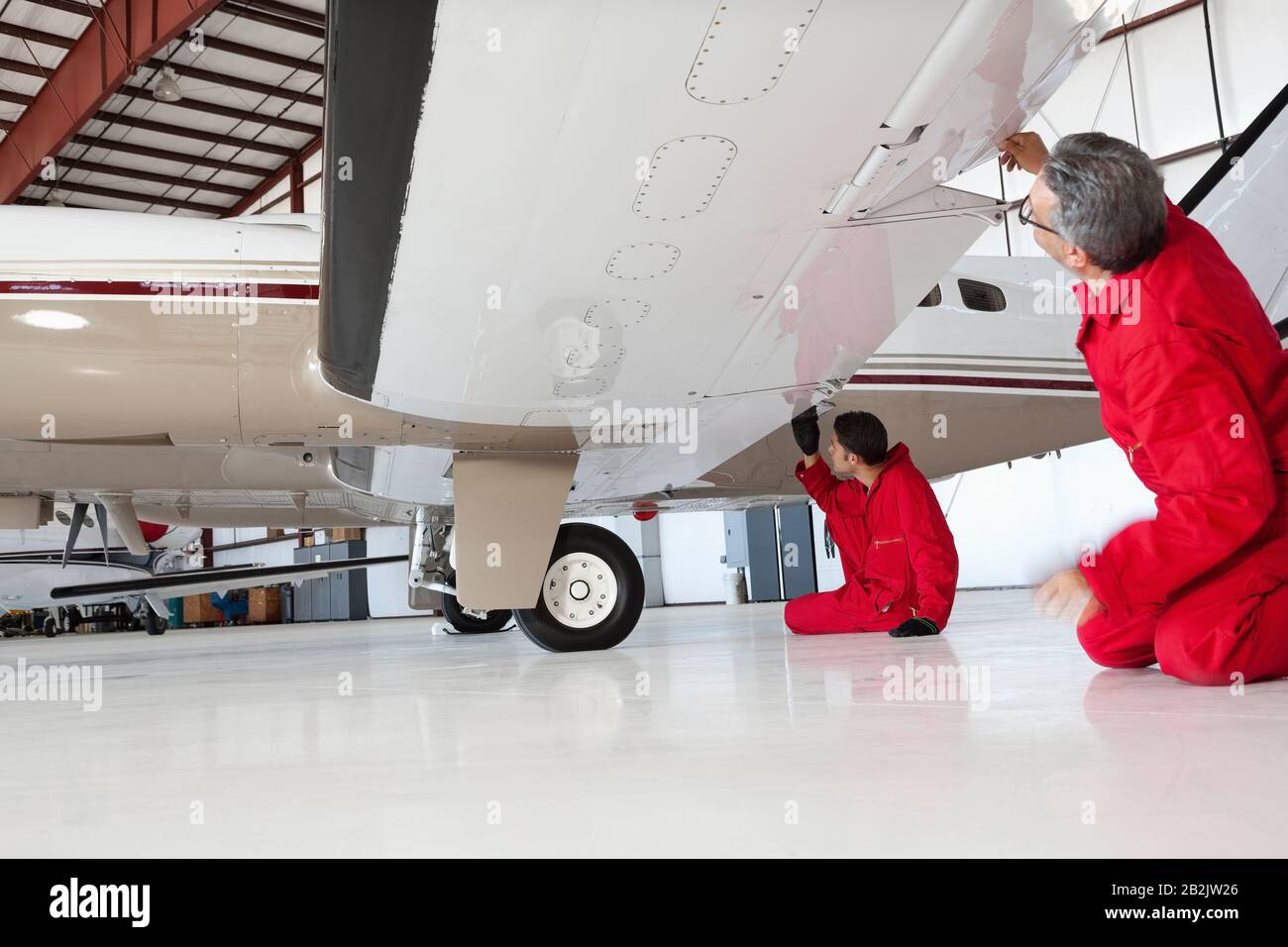 Flugmechaniker inspizieren Flugzeugflügel Stockfoto