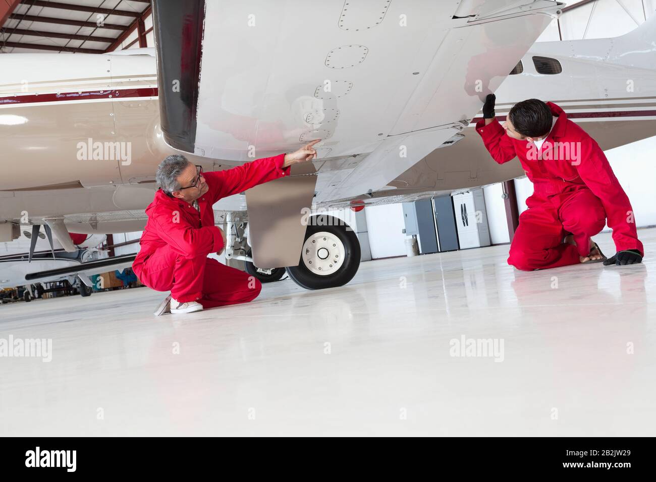 Flugmechaniker inspizieren Flugzeugflügel Stockfoto