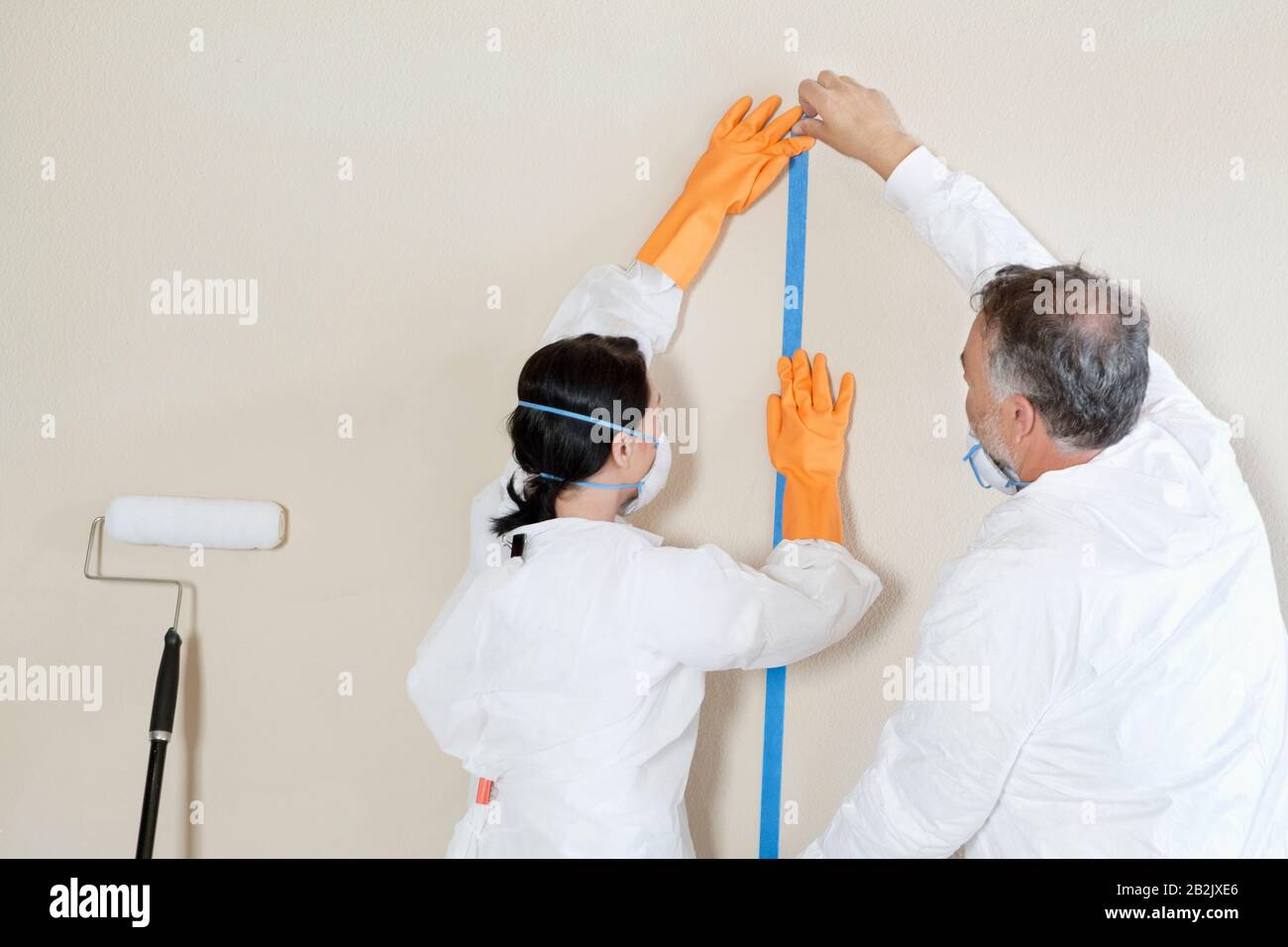 Rückansicht von zwei manuellen Mitarbeitern, die die Vorbereitung auf den Lackierraum durchführen Stockfoto