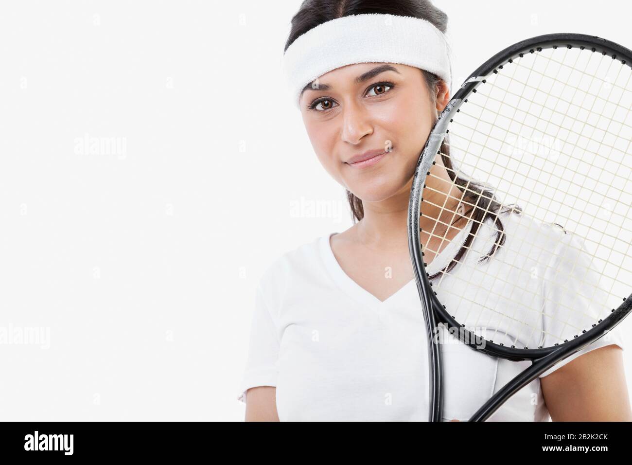 Porträt der jungen Asiatin mit Tennisschläger vor weißem Hintergrund Stockfoto