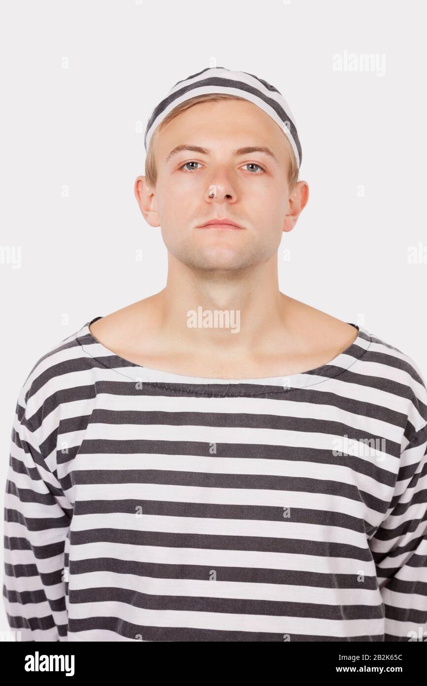 Porträt des jungen Mannes mit Häftlingsuniform vor grauem Hintergrund Stockfoto