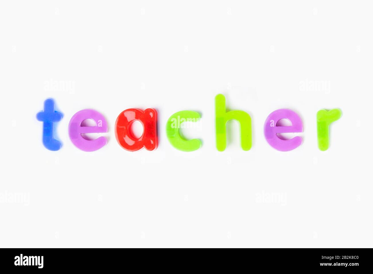 Alphabetmagnete schreiben "Lehrer" über weißem Hintergrund Stockfoto