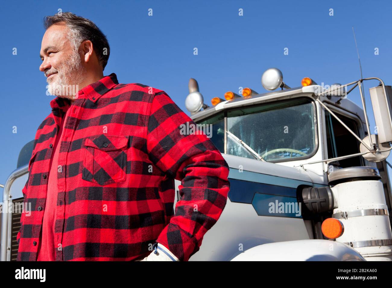 Trucker steht vor Cargo Truck Stockfoto