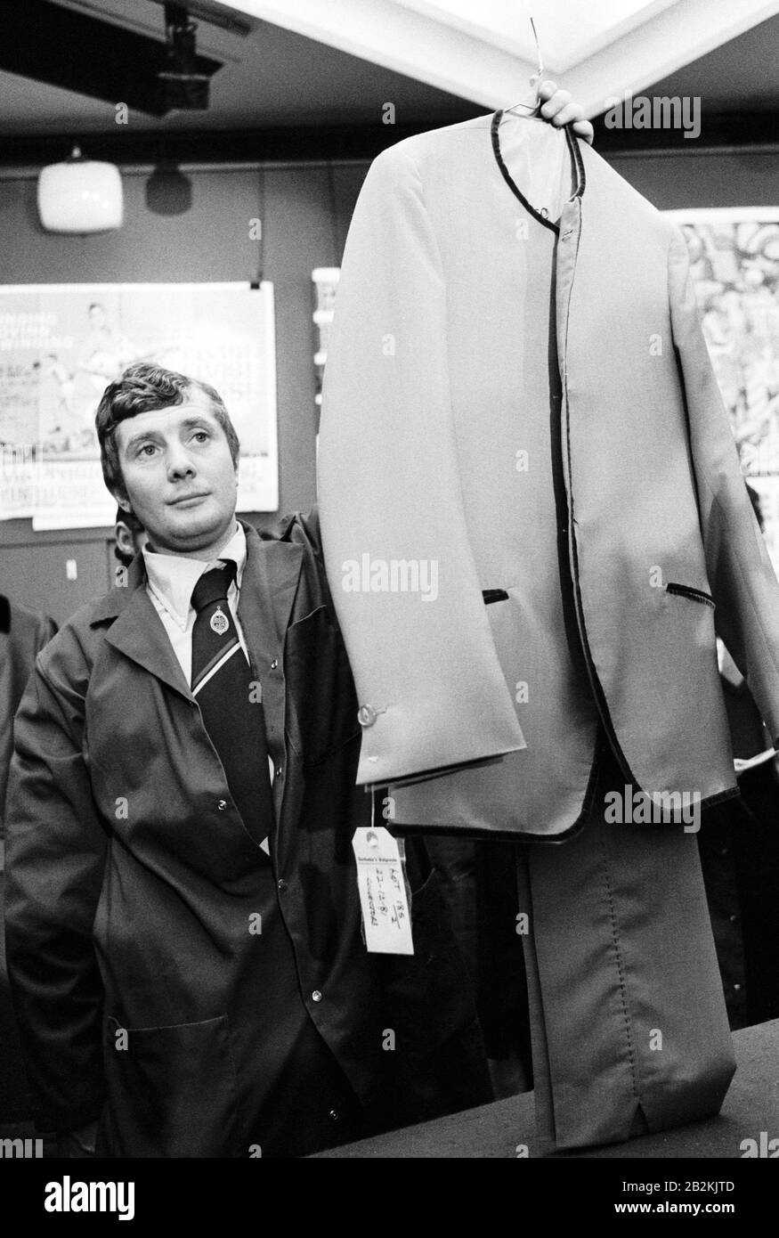 Ein Sotheby's Porter, der John Lennons Bühnenanzug hält, Los 185 bei einer Auktion von Rockmusik-Memorabilien in den Londoner Auktionsräumen. Der Anzug aus dem Jahr 1965 wurde für 2.300 £an einen privaten Sammler verkauft. Stockfoto