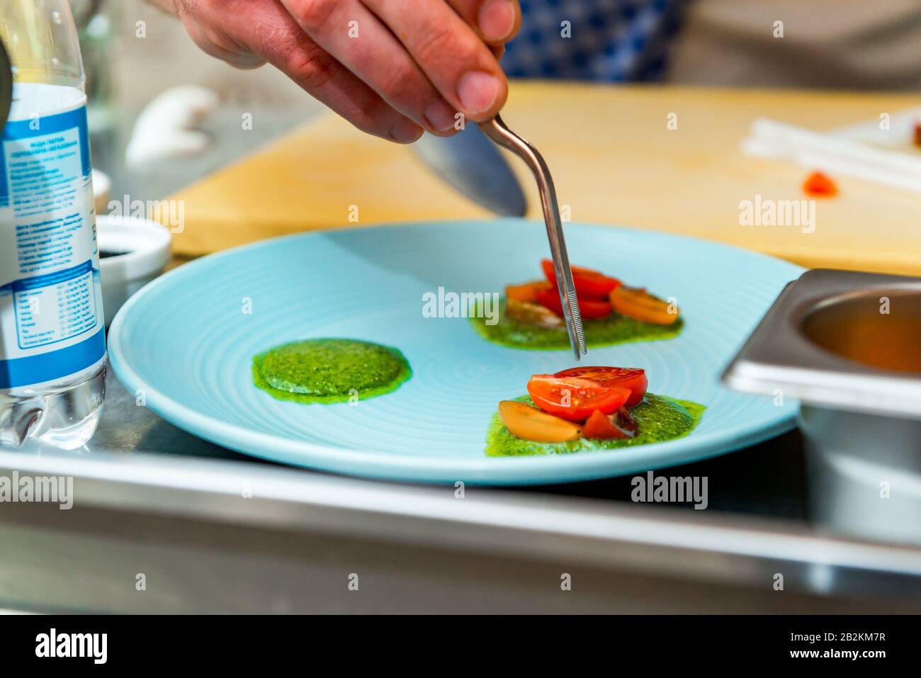 Der Koch im Restaurant bereitet ein Gericht zu, er beendet das Gericht auf einem Teller Stockfoto