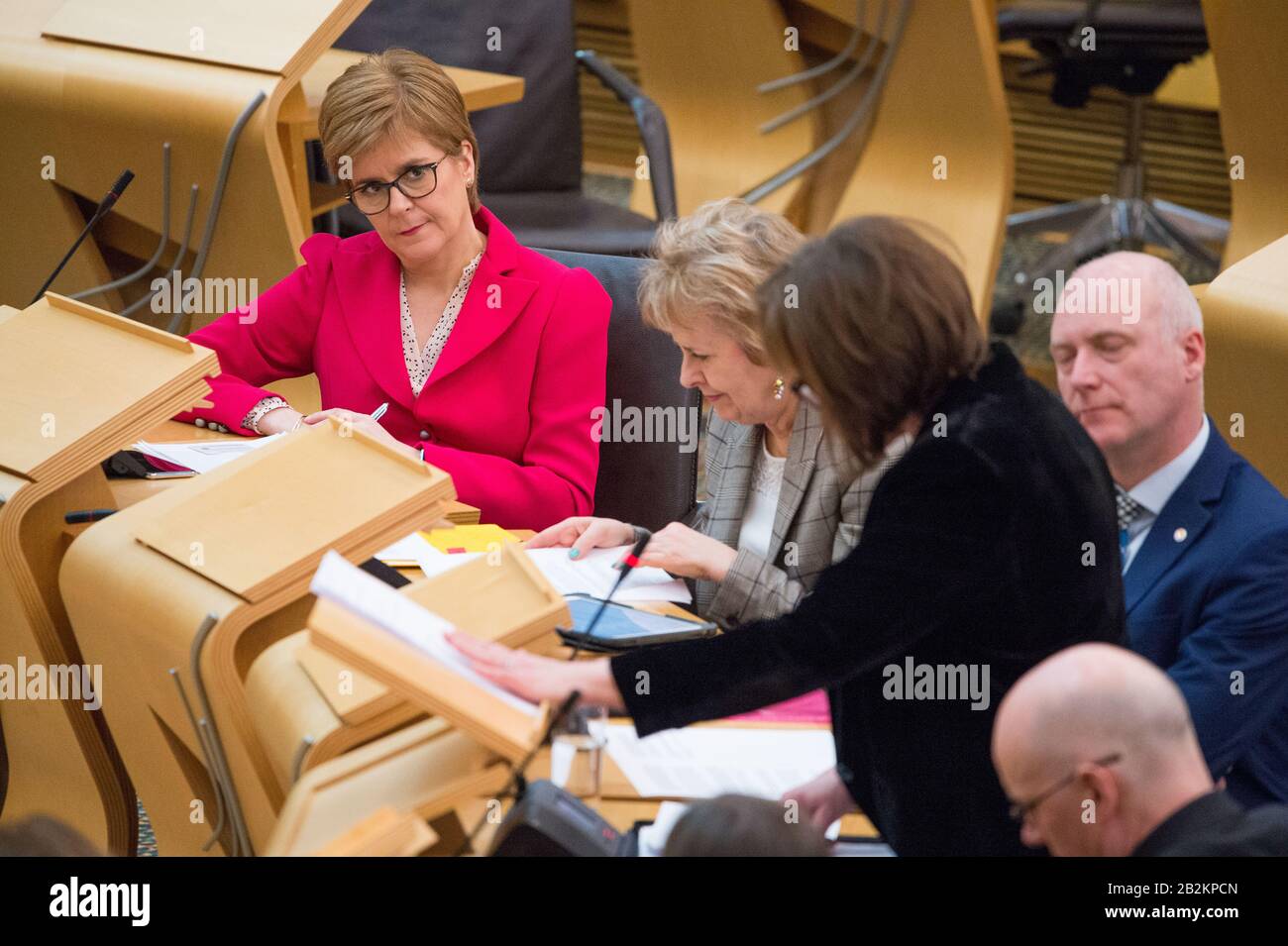 Edinburgh, Großbritannien. März 2020. Abgebildet: (In Rosa) Nicola Sturgeon MSP - Erster Minister und Führer der Scottish National Party (SNP); (in Schwarz), Jeane Freeman MSP - Kabinettsministerin für Gesundheit und Sport. Ministererklärung von Gesundheitsministerin Jeane Freeman MSP über den Bundesstaat Coronovirus und Schottlands Bereitschaft, die Verbreitung des Virus in Schottland zu mildern. Szenen aus dem schottischen Parlament in Holyrood, Edinburgh. Kredit: Colin Fisher/Alamy Live News Stockfoto