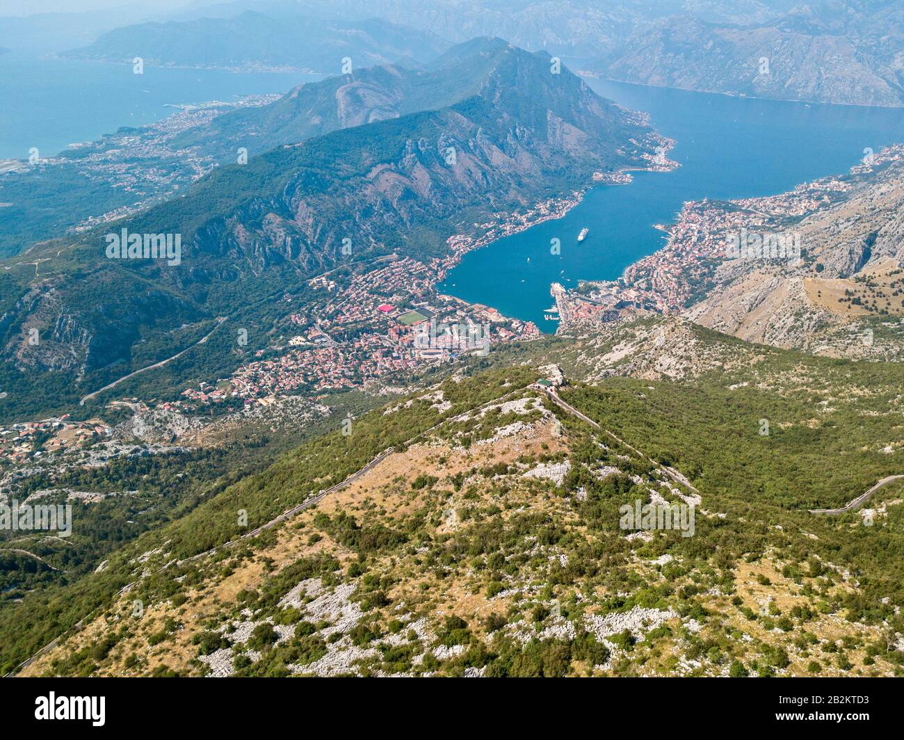 Luftbild zur Bucht von Kotor, Boka. Malerische Straße mit Blick auf die Bucht des Kotor-Fjords. Kurvenreiche Straßen, um Montenegro zu entdecken. Tourismus und Bootstour sh Stockfoto