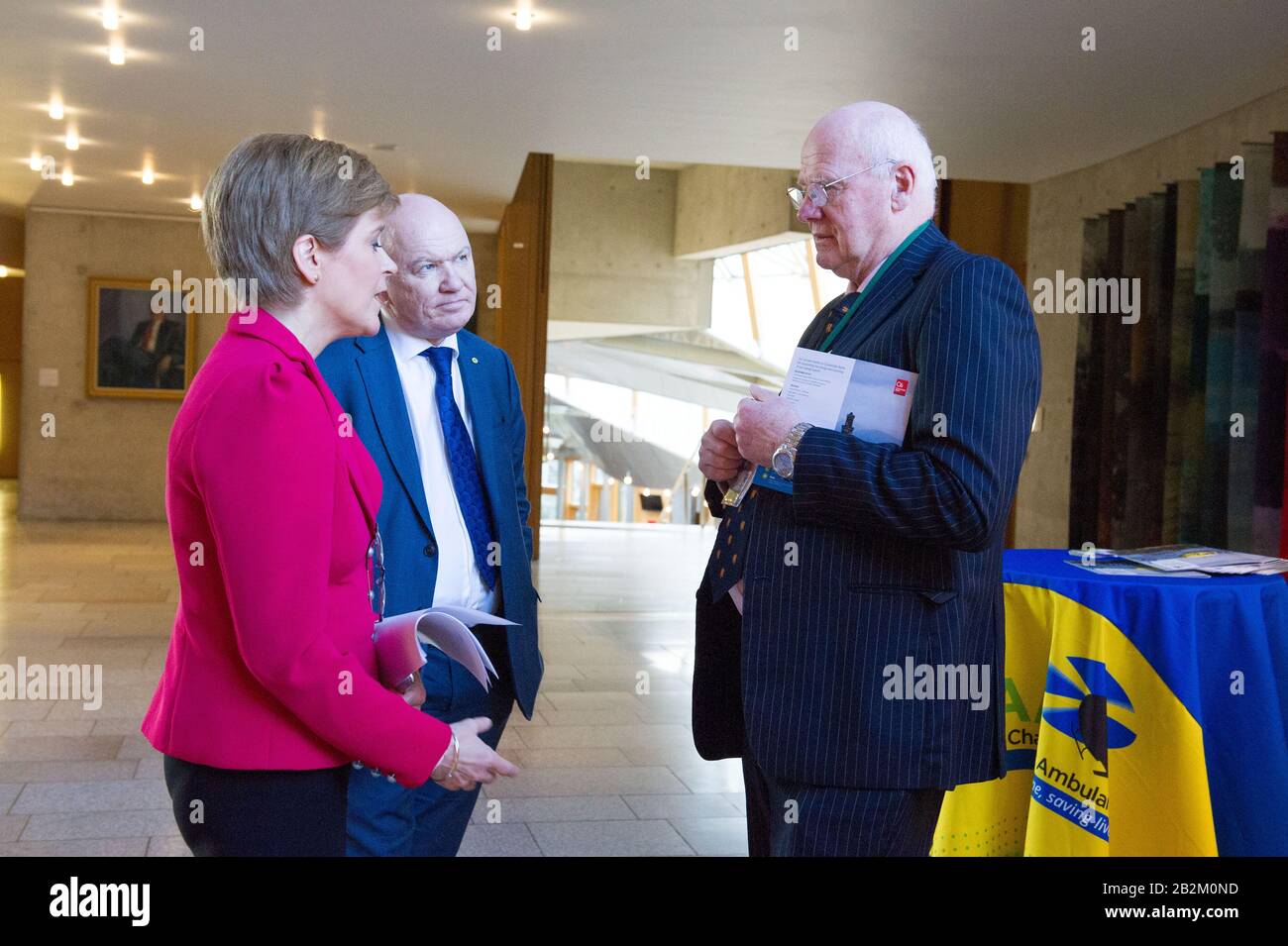 Edinburgh, Großbritannien. März 2020. Abgebildet: (L-R) Nicola Sturgeon MSP - Erster Minister von Schottland und Führer der Scottish National Party (SNP); Gordon MacDonald MSP - Scottish National MSP für den Wahlkreis Edinburgh Pentlands; Mike Beale - Vice Chairman of Scotland's Charity Air Ambulance. Szenen aus dem schottischen Parlament in Holyrood, Edinburgh. Kredit: Colin Fisher/Alamy Live News Stockfoto