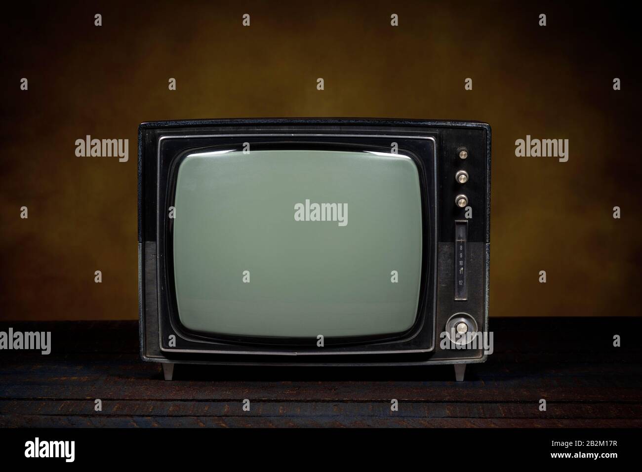 Altes tragbares Fernsehen. Holztisch und brauner Hintergrund. Konzept der Veralterung, Modernisierung oder technologischen Revolution Stockfoto