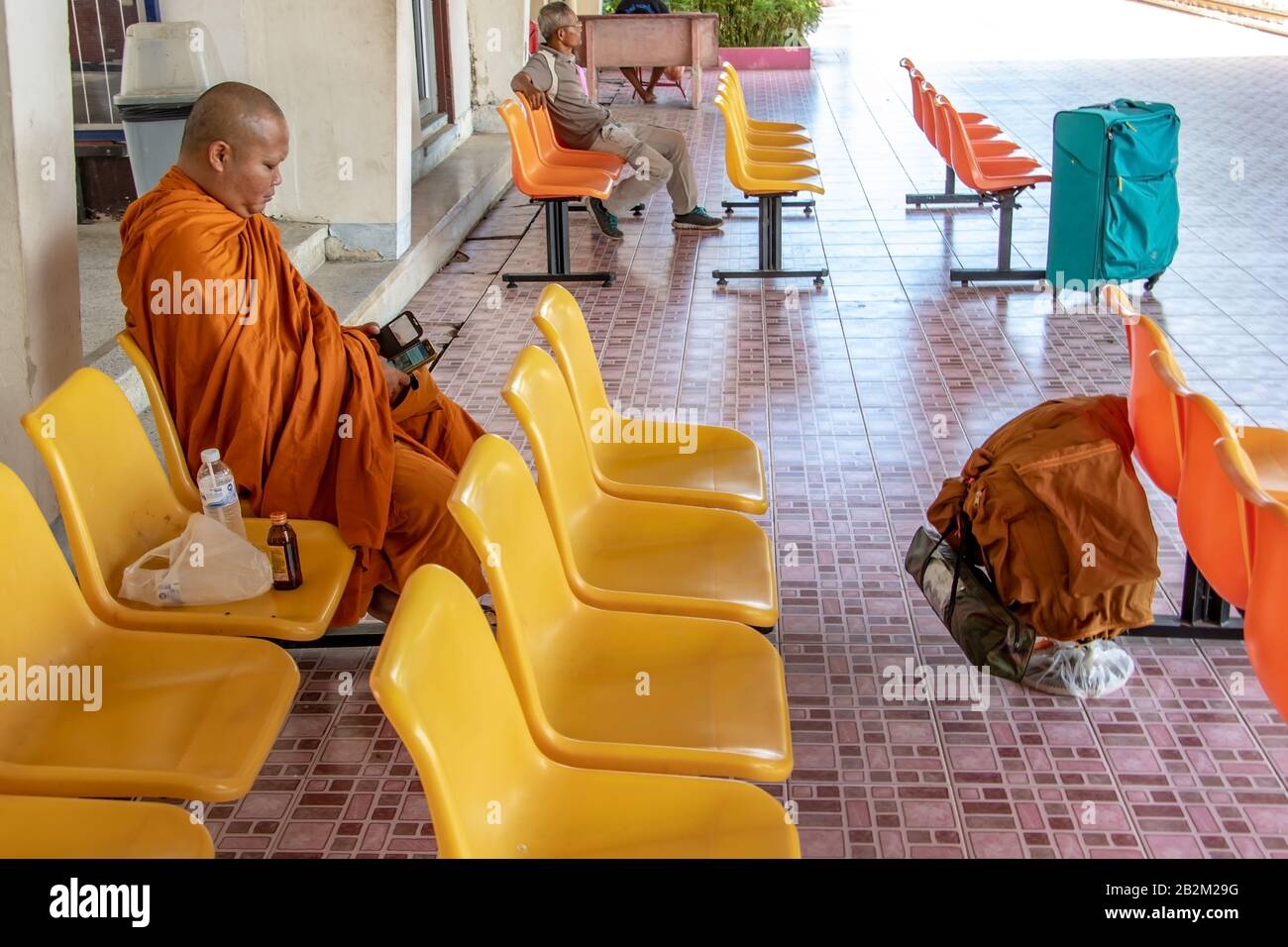 PHOTHARAM, THAILAND, Jun 02 2018, buddhistischer Mönch auf dem Bahnsteig sitzend und auf den Zug wartend Stockfoto