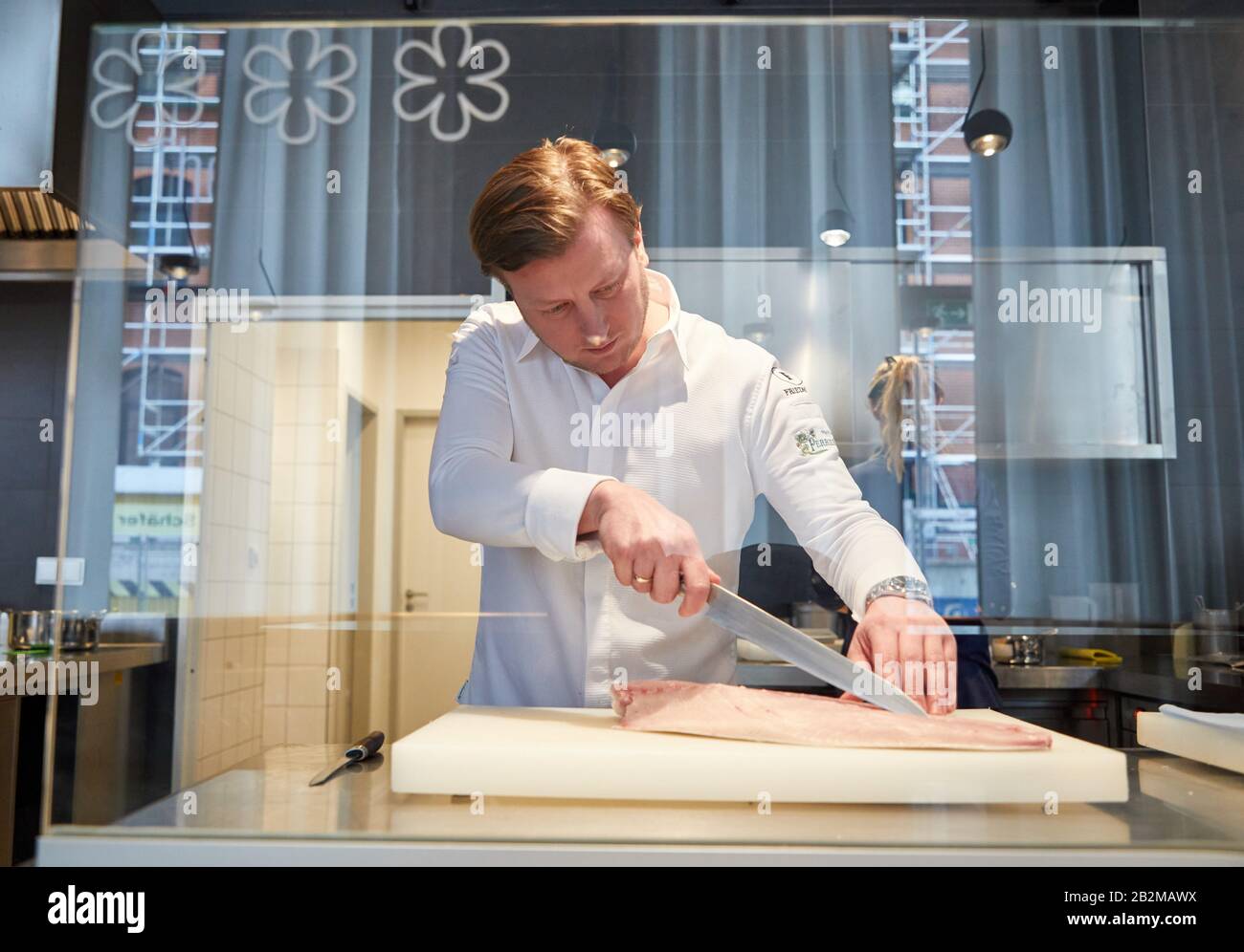 Hamburg, Deutschland. März 2020. Kevin Fehling, Spitzenkoch, steht in seinem Restaurant The Table Kevin Fehling und schneidet ein Fischfilet. Restaurantführer Michelin Deutschland hat die Stars der besten Restaurants angekündigt. Mit dem Zustandekommen von Berlin verfügen Deutschlands drei größten Städte erstmals über ein Drei-Sterne-Restaurant. In Hamburg konnte "Der Tabellenerste Kevin Fehling" den Spitzenpreis halten. Kredit: Georg Wendt / dpa / Alamy Live News Stockfoto